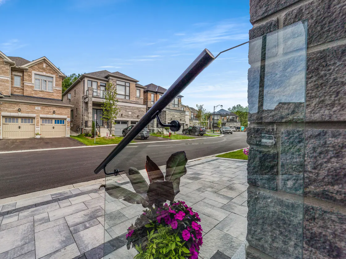 Black handrail turning down the steps of a custom glass entry