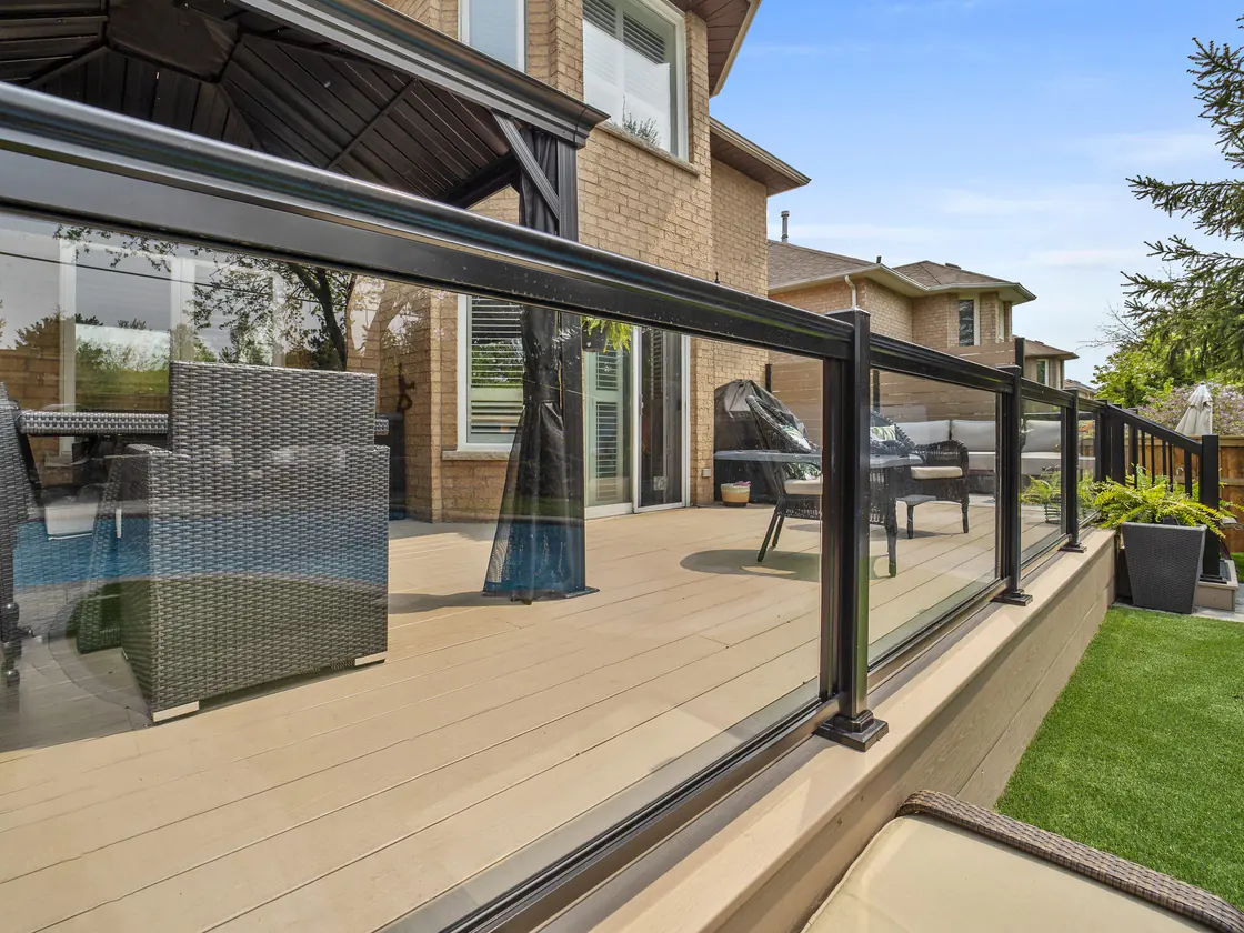 Framed glass railing with a black top rail on a deck