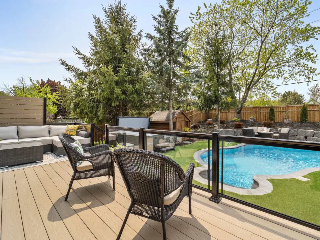 Glass railing with black posts around a pool deck