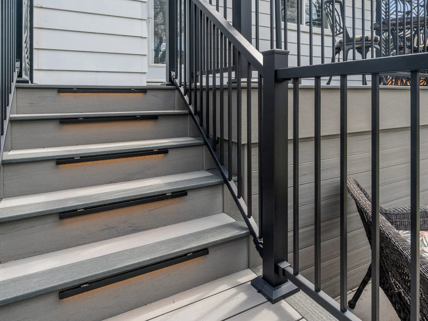 Black aluminum picket railing on deck stairs with a graspable top rail
