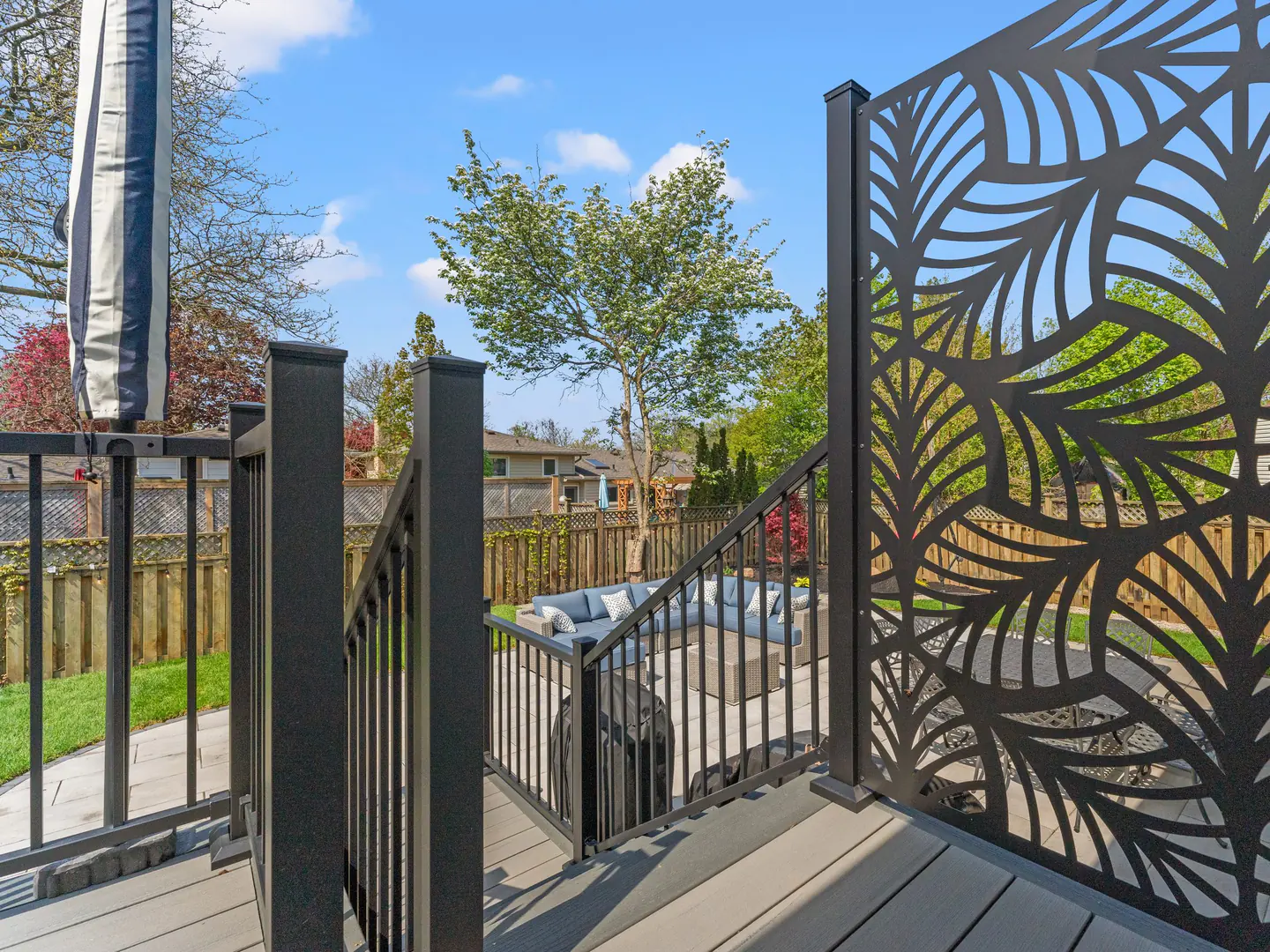 Aluminum railing with a decorative privacy panel on a backyard deck