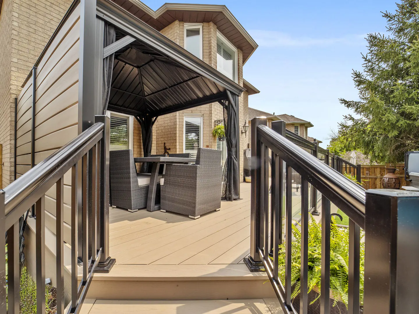 Framed glass railing with black posts carried down a deck stair