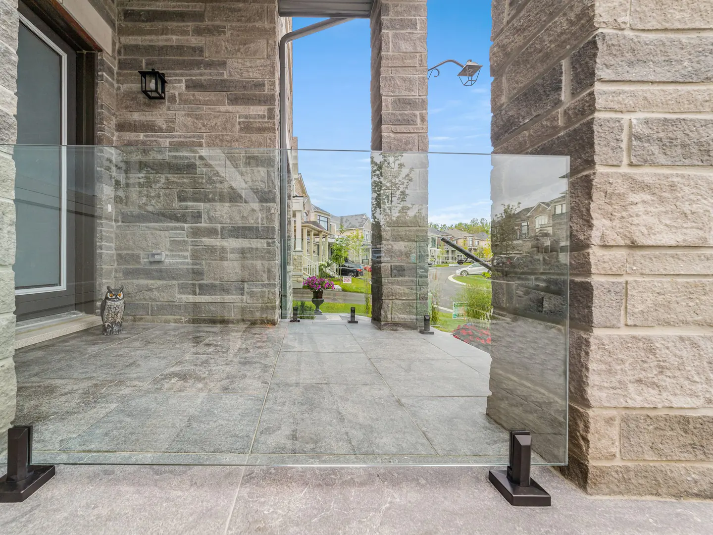 Frameless glass panels on spigots at a covered front entry